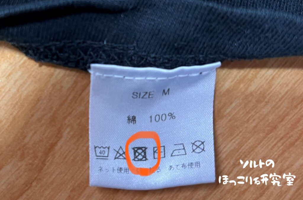 衣類の洗濯表示にタンブル乾燥禁止マークが記載されている様子。